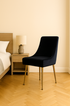 Black chair with gold legs in a bedroom setting